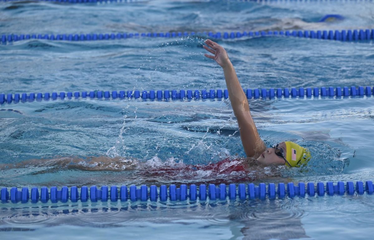 Eliana raises her arm into the air, perfecting her backstroke form. With a total of five hours of training, Eliana finds every opportunity during her day to work on her school assignments to manage her workload. 