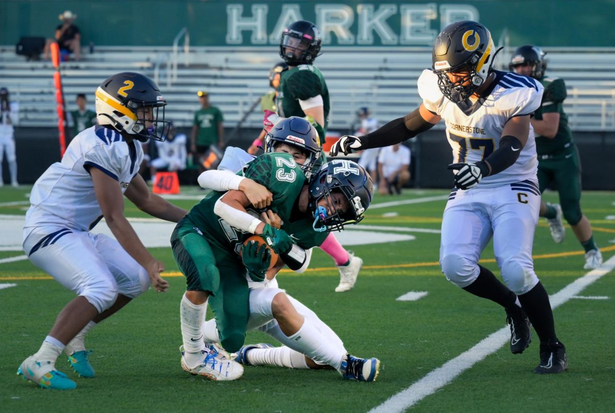 Running back Pedro Castro III clings to the football as Cougar defenders drag him down during the season opener match. The Eagles went 5-3 in the Pacific Coast Athletic League.