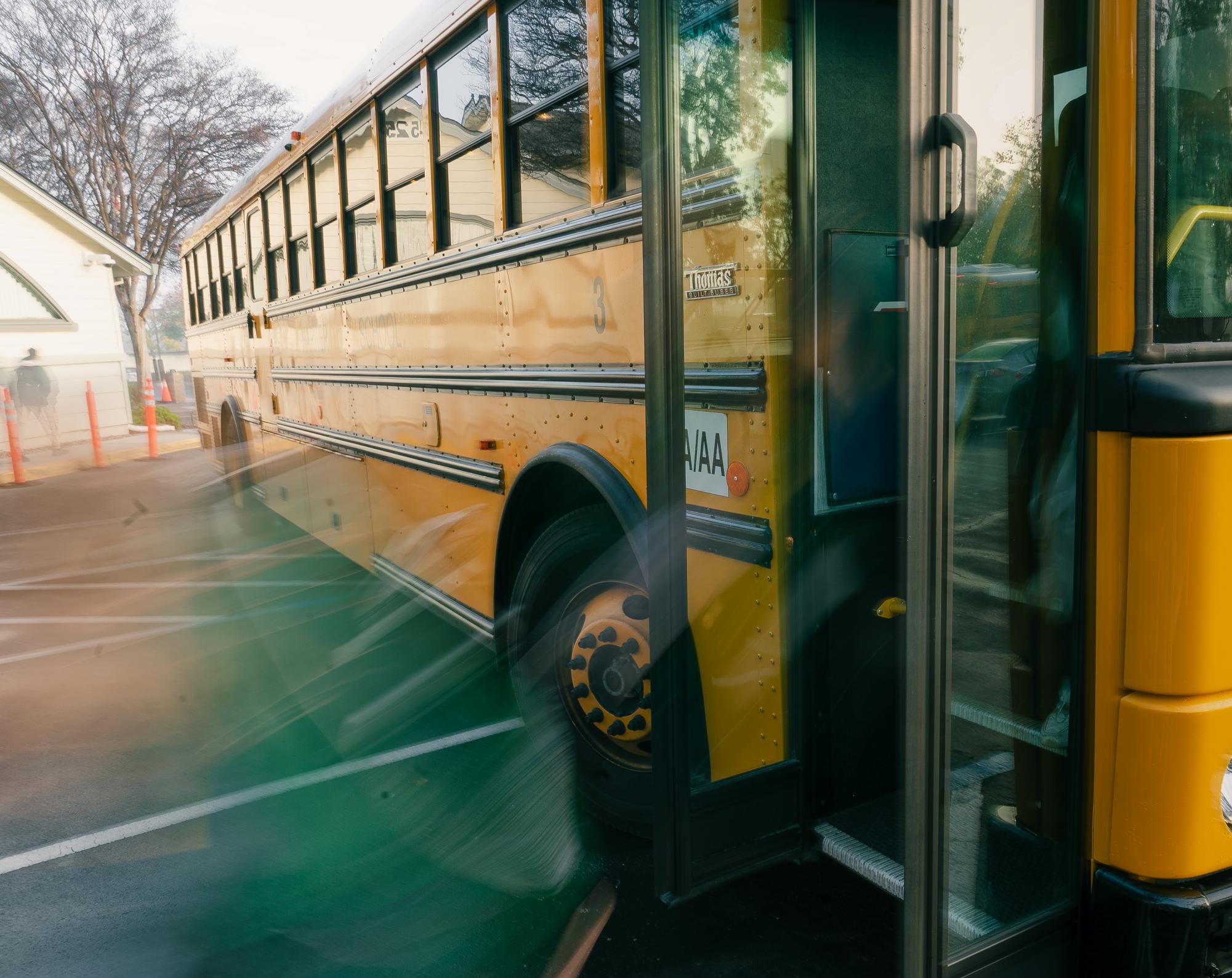 Middle school students disembark bus driver Scott Milheim's 7:55 a.m. shuttle. Before stepping out, each student scanned a specialized transportation card to confirm that they had safely made the trip.