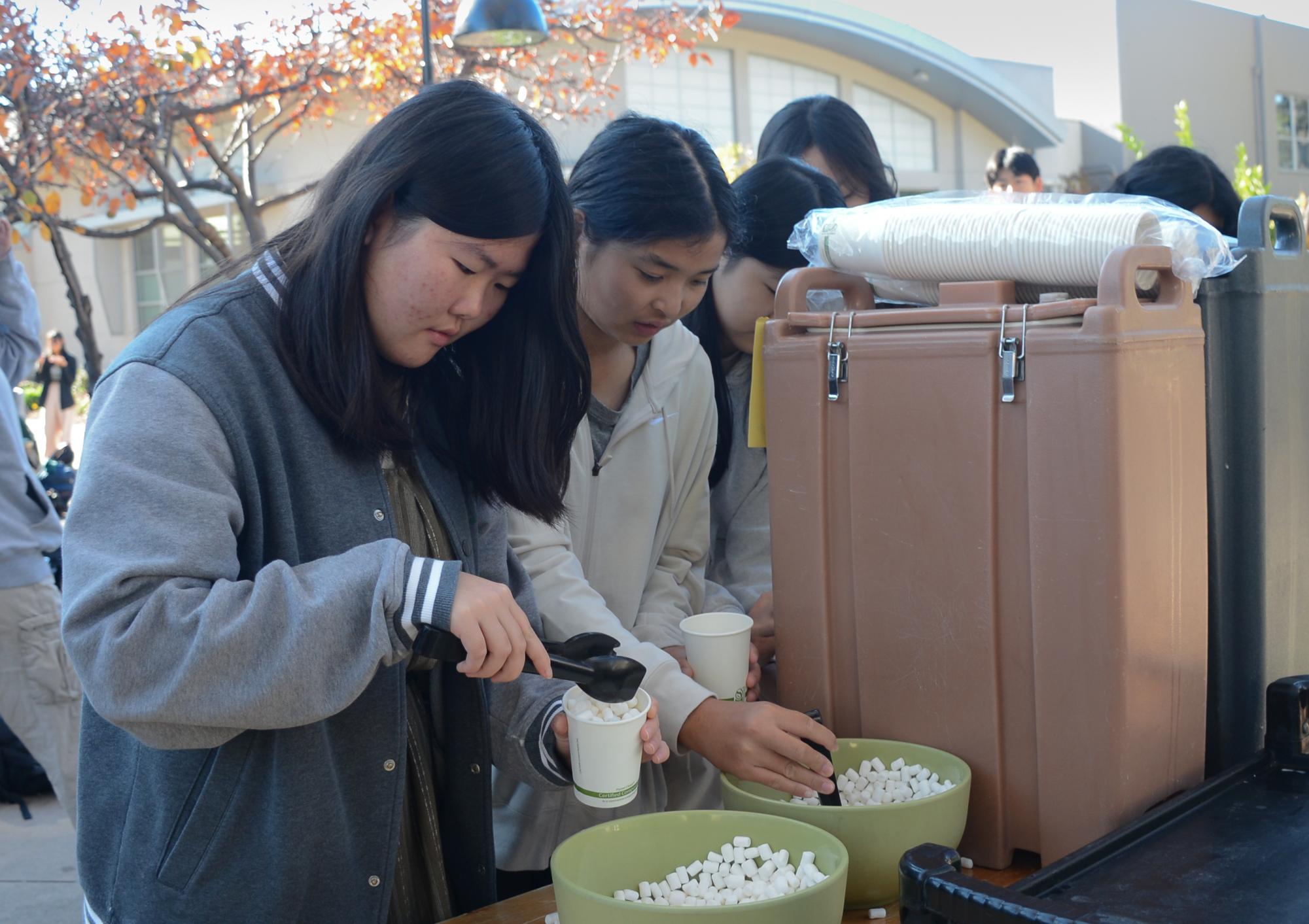 Frosh Madelene Hu scoops marshmallows into her cup of hot chocolate. Destress Week started on Monday and featured four days of activities to help students relax.