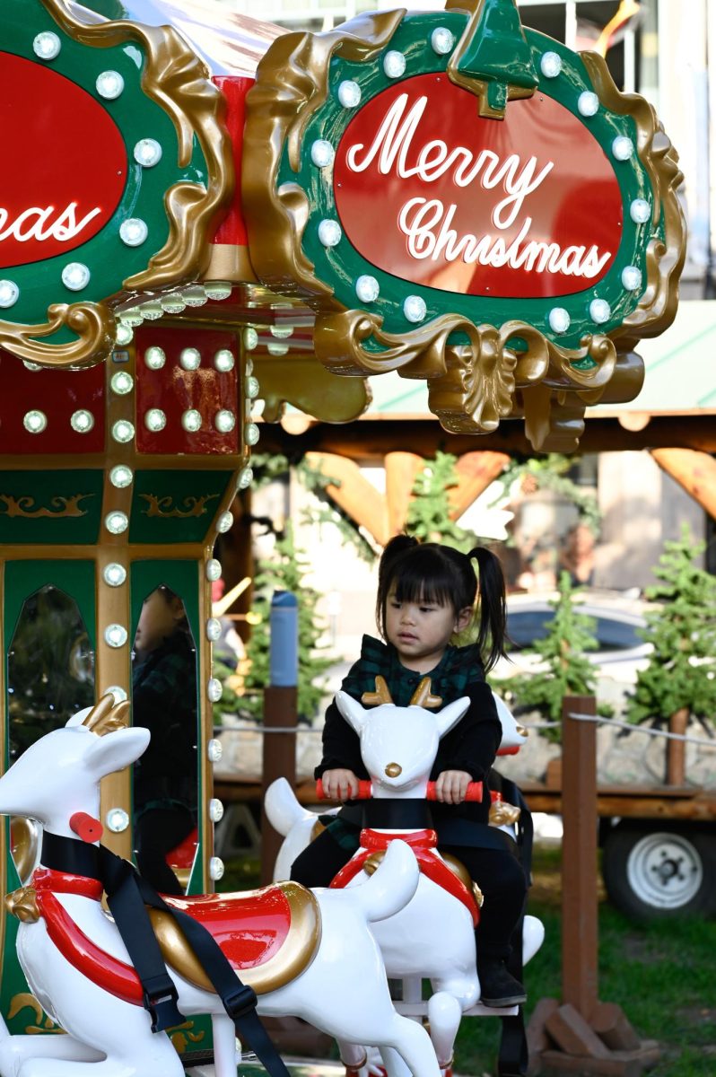 A young girl rides the Christmas themed carousel. Along with life-sized dioramas and intricate displays, the event also features amusement park style ride, like ferris wheels and claw rides.