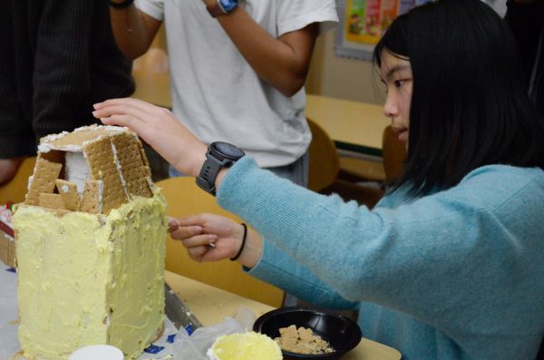 Sophomore Alice Luo adds frosting to her class' gingerbread house. "There were so many people working on it and so many moving parts, but we all were trying to do well," Alice said.