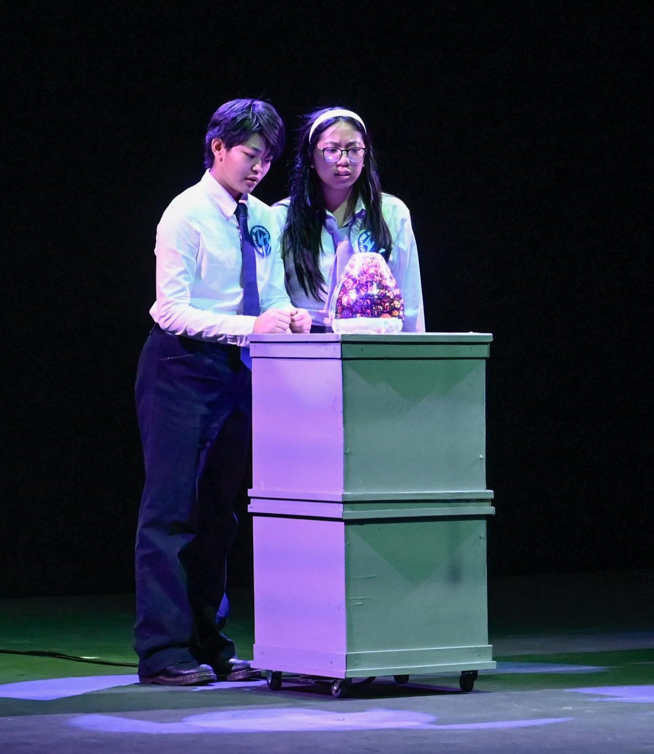 Paul Farrel, played by senior Emily Su, and Lynn Swift, played by senior Caitlyn Wong, ask the machine for guidance. "I wanted to do a show that left an impact on the audience and made them think," Avayna said.