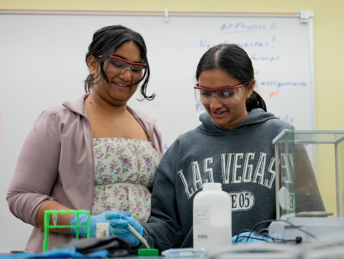 Sophomores Laya Sunkara and Arshia Sankar measure out a chemical using a scoopula. The broad goal of their research project is to investigate DNA repair mechanisms through a particular gene.