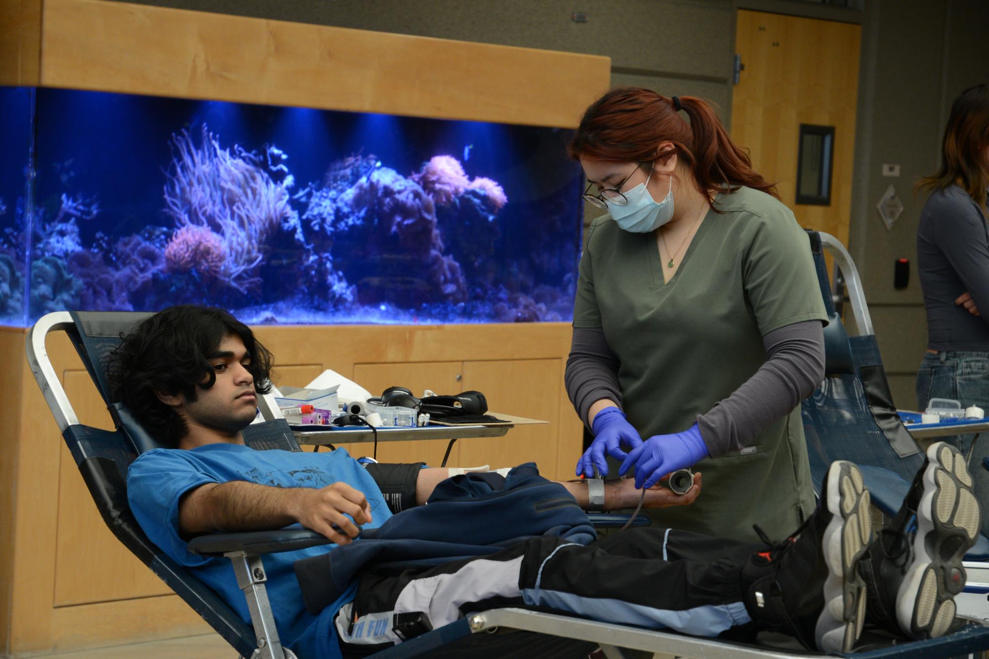 Pranav Sukesh (12) reclines on a medical chair as a medical professional attends to his arm. All donors were given a $15 E-Gift Card Promo and a special edition Golden State Warriors hoodie as a gesture of gratitude.