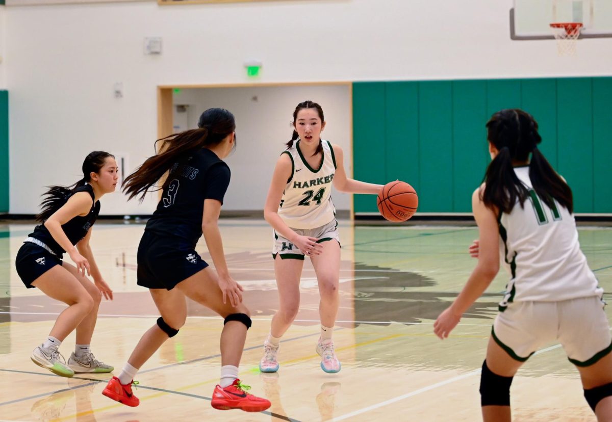 Forward Gemma Chan (12) dribbles the ball past Notre Dame players. While the Eagles made many defensive rebounds, they struggled to counter the Regents' strong offense.