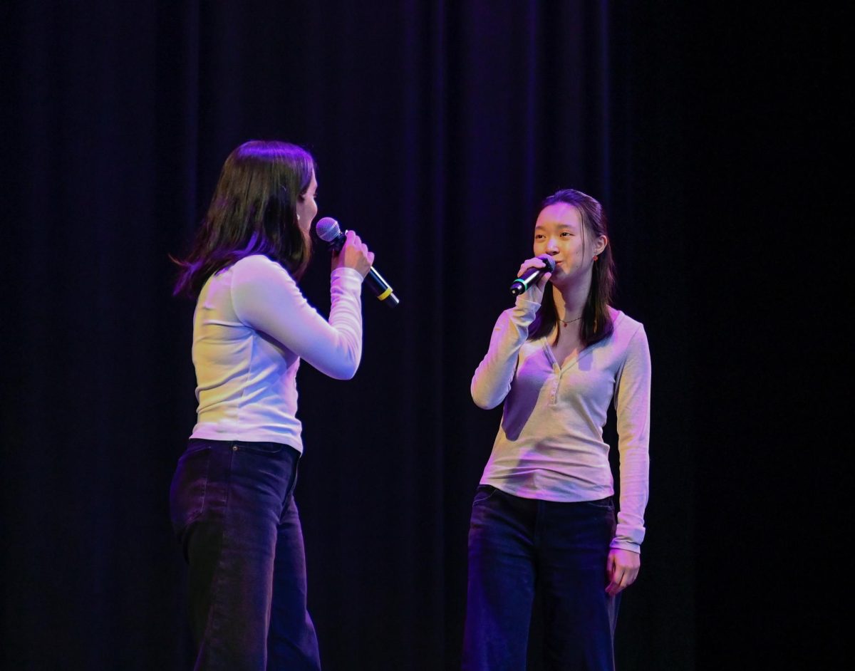 Sophomores Megha Unny and Sophia Zhu smile as they sing together onstage. They harmonized in a cover of Sam Smith’s “Stay With Me."