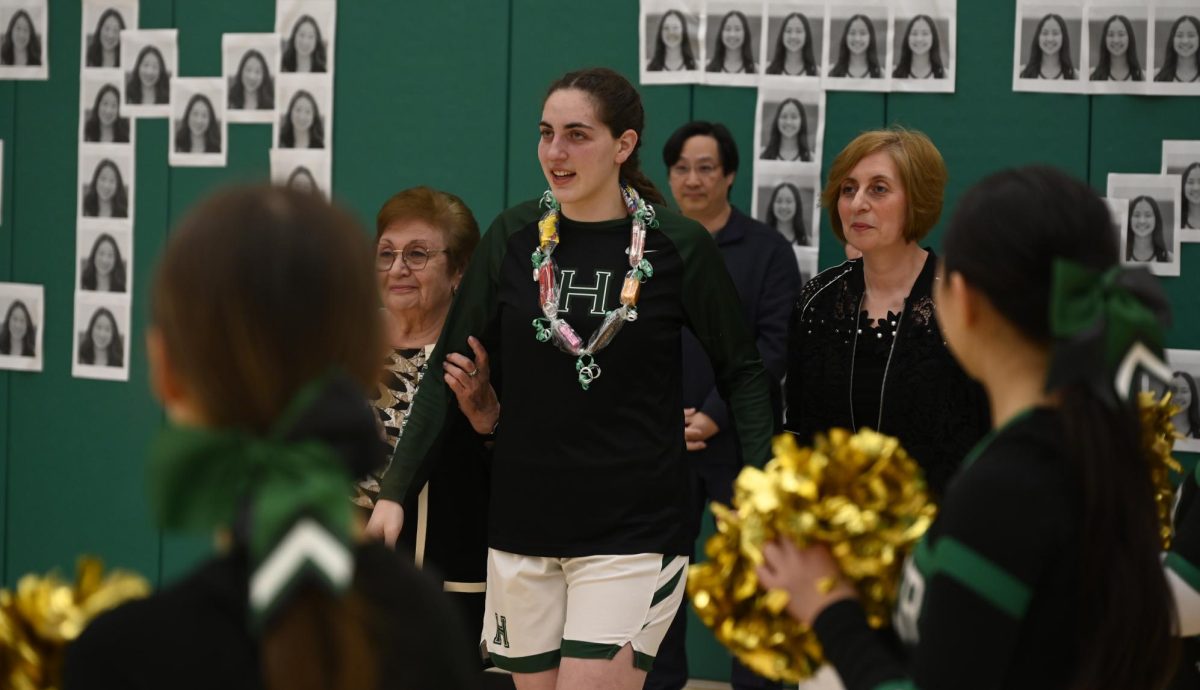 Holding her grandmother and mother, senior Emily Mitnick prepares to receive her flowers for senior night. "It's a very special feeling to be able to contribute to the team and put us in a position where we can keep going in this season," Emily said, referencing their #3 seed in CCS.