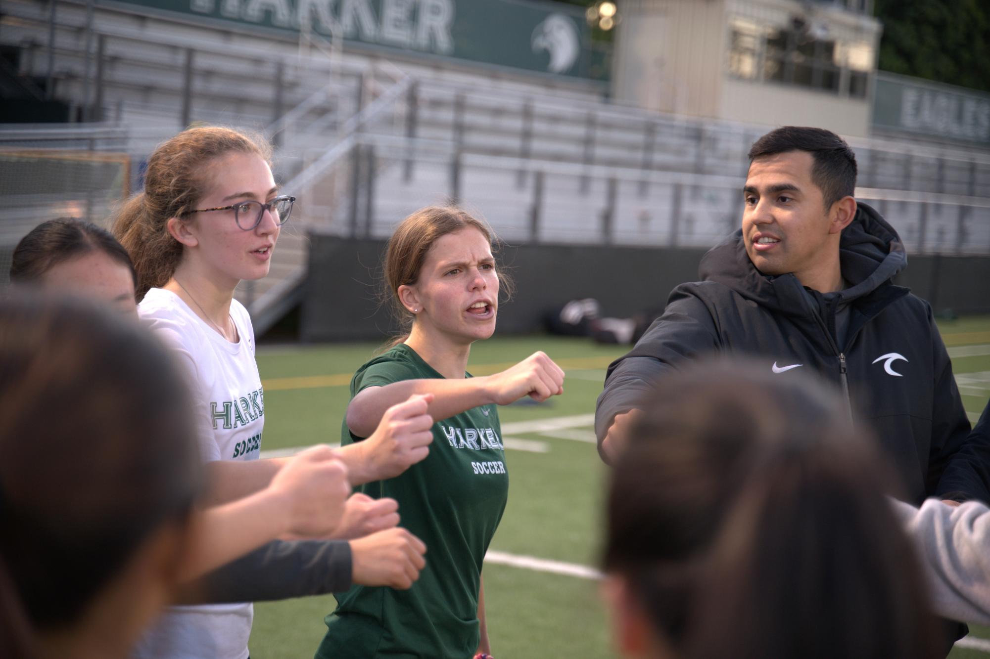 Varsity girls soccer captain Claire Anderson (12) leads a team cheer at the end of practice. Beyond setting examples during the match, captains play a role in managing practices and team activities off the field