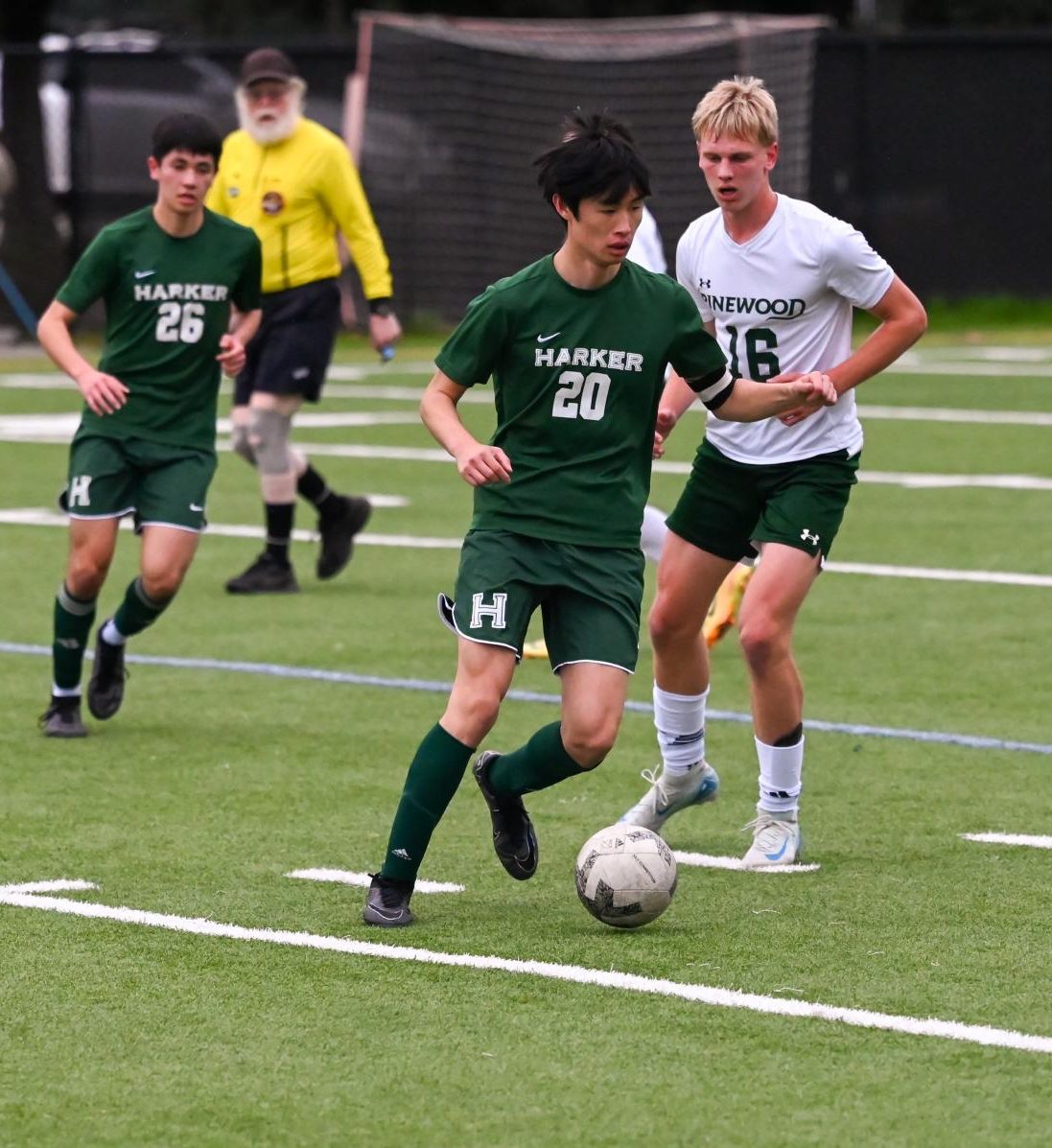 Defender Jonathan dribbles the soccer ball past Pinewood players. From his position in the center of the field, Jonathan communicated with the back line to prevent Pinewood from breaking through.