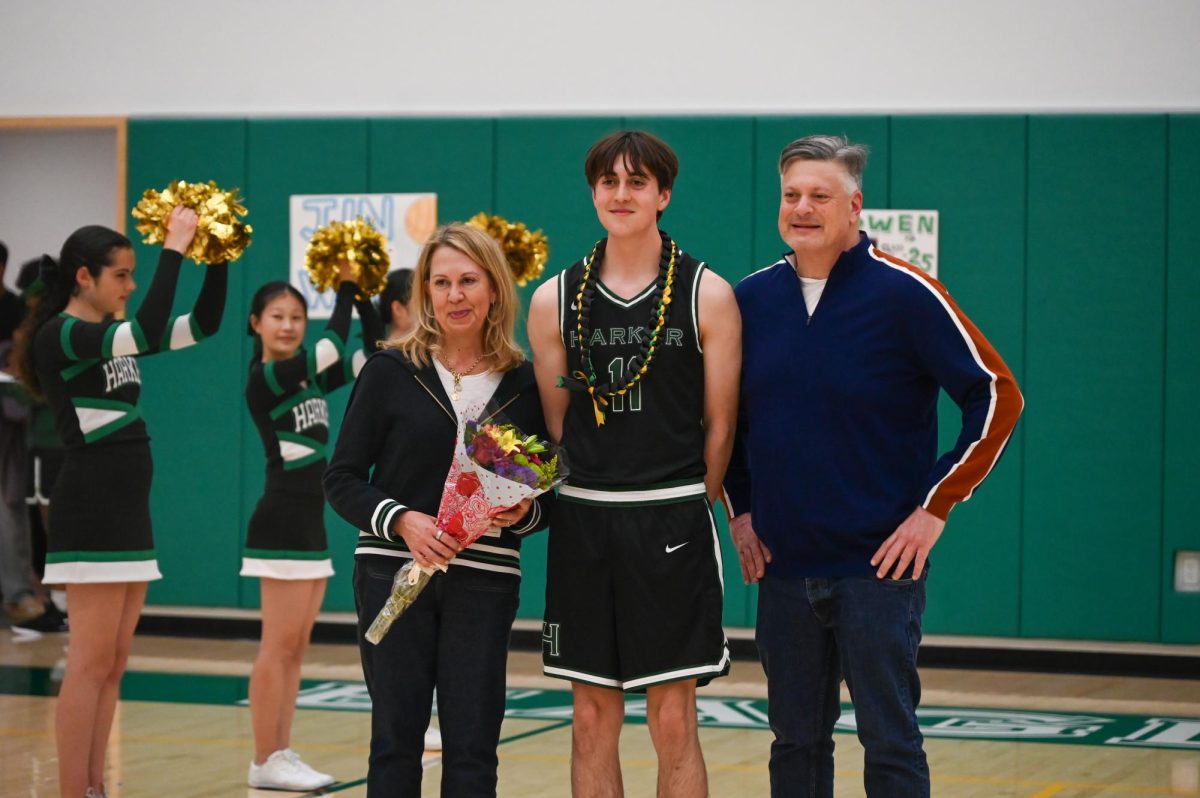 Small forward Haden Andrews (12) poses for a photo with his parents. As each senior took their photo, head coach Alfredo Alves shared highlights about their time playing basketball at Harker. 