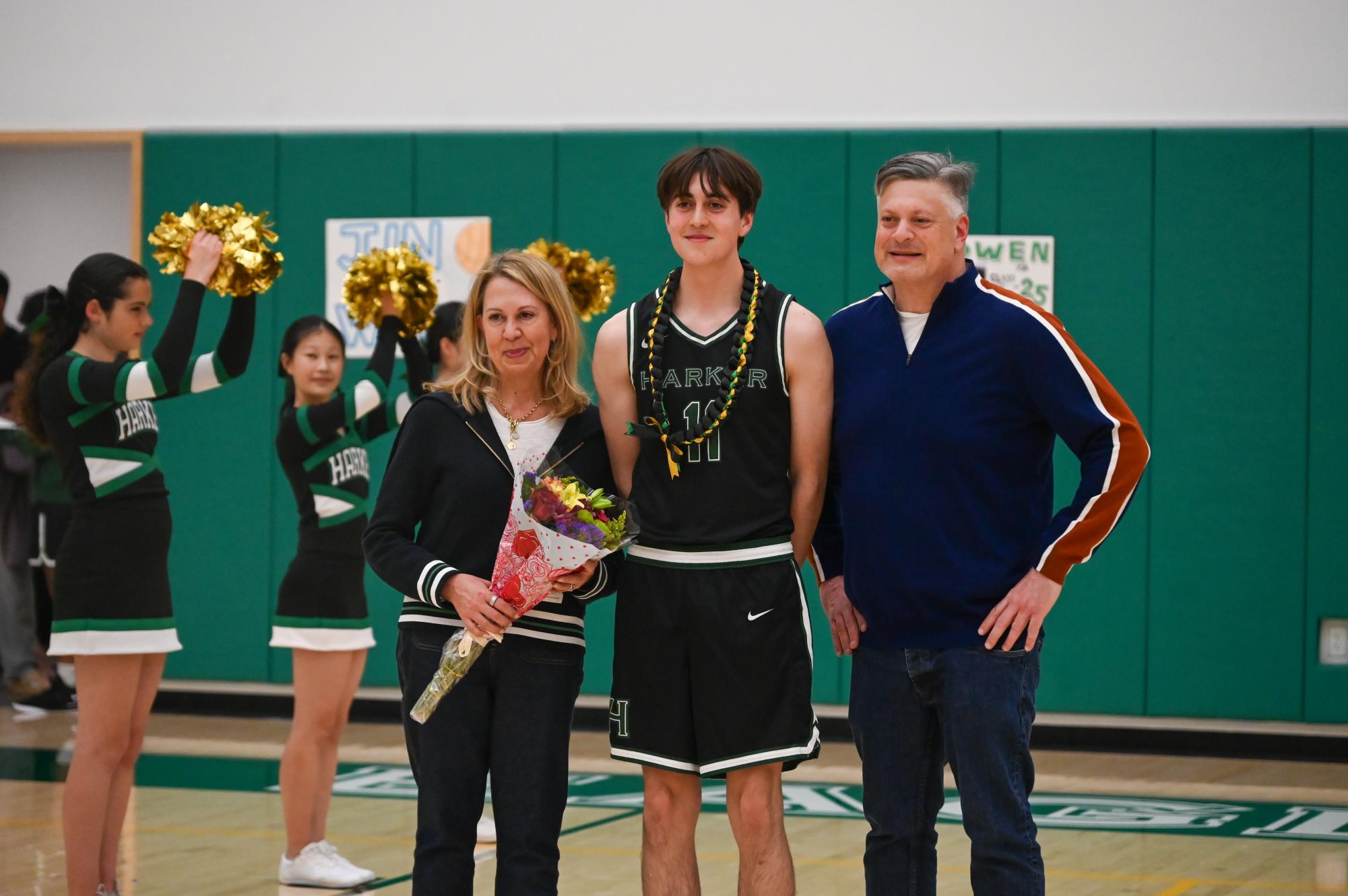 Small forward Haden Andrews (12) poses for a photo with his parents. As each senior took their photo, head coach Alfredo Alves shared highlights about their time playing basketball at Harker. 