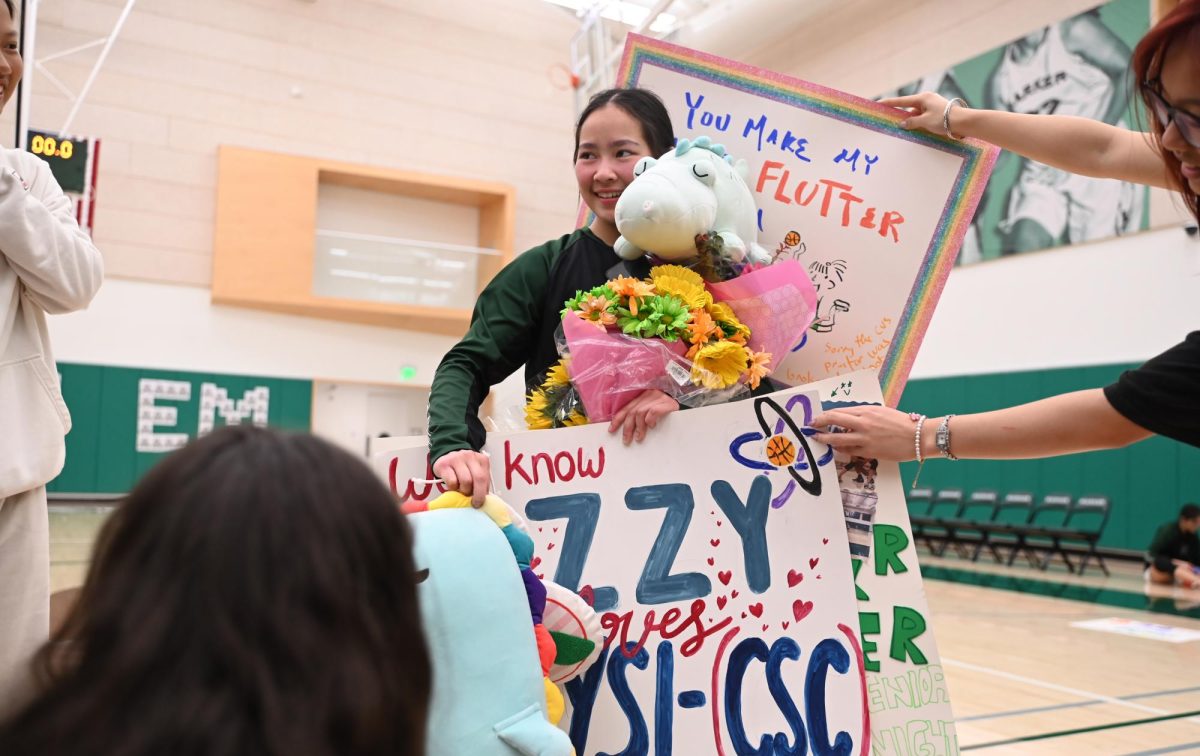 Guard Isabella Lo (12) receives posters, flowers and plushies during varsity girls basketball senior night. After the game against Eastside concluded, the seniors took photos with their friends to celebrate their last home game of their high school careers.