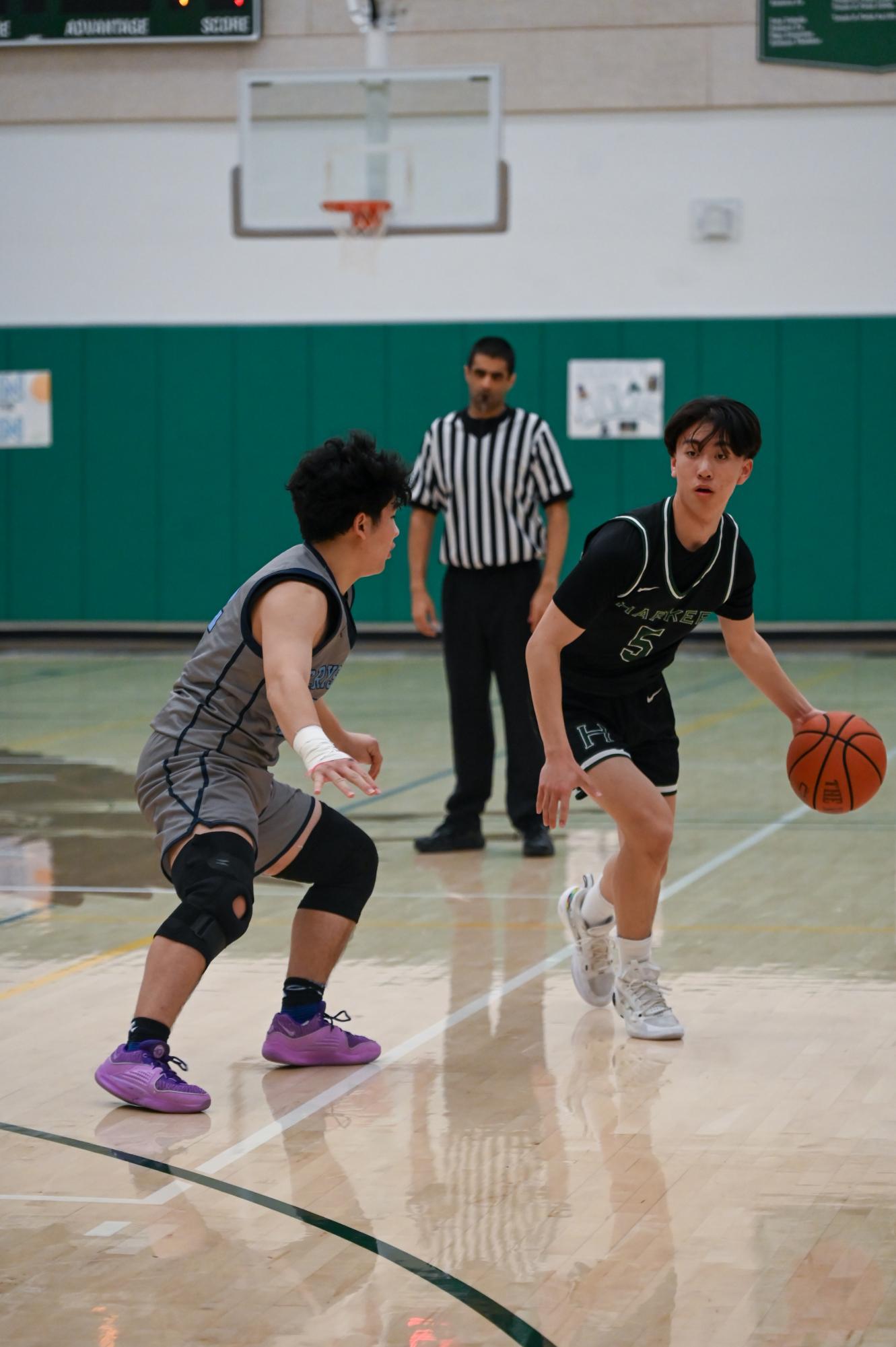 Point guard Gary Jin (12) dribbles the ball down the court. “It was really important in this game for everyone to go out and have fun, especially since it’s one of our last games,” Gary said.