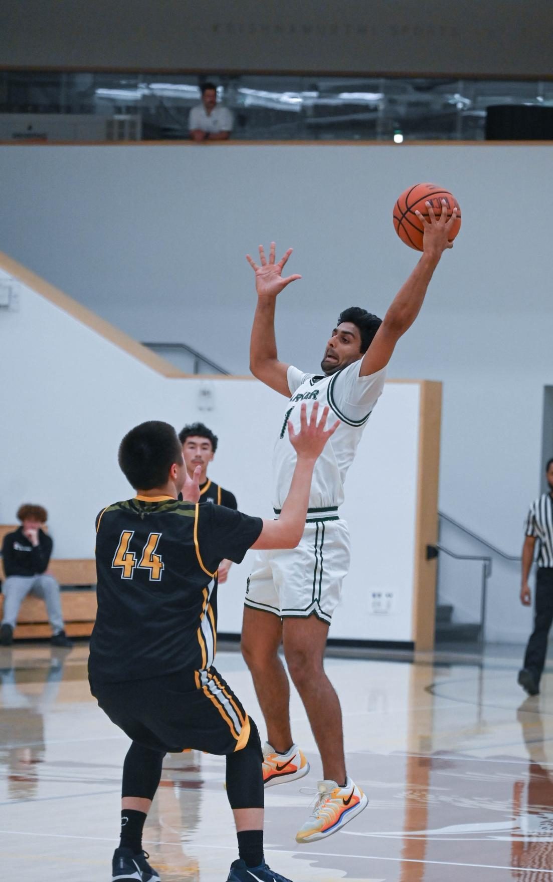 Power forward Vyom Vidyarthi (12) leaps into the air to prepare for a shot. Despite losing the opening tipoff, Harker responded with aggression to gain the lead by the end of the first quarter.