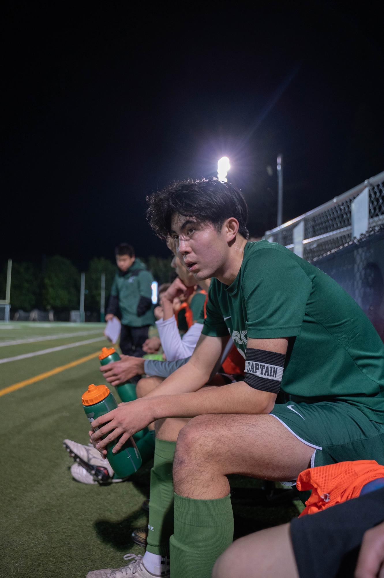 Varsity boys soccer captain Alec Zhang (12) watches the game intently, looking for moments to coach his teammates. The captains all wear arm bands to display their authority to referees and opponents. 