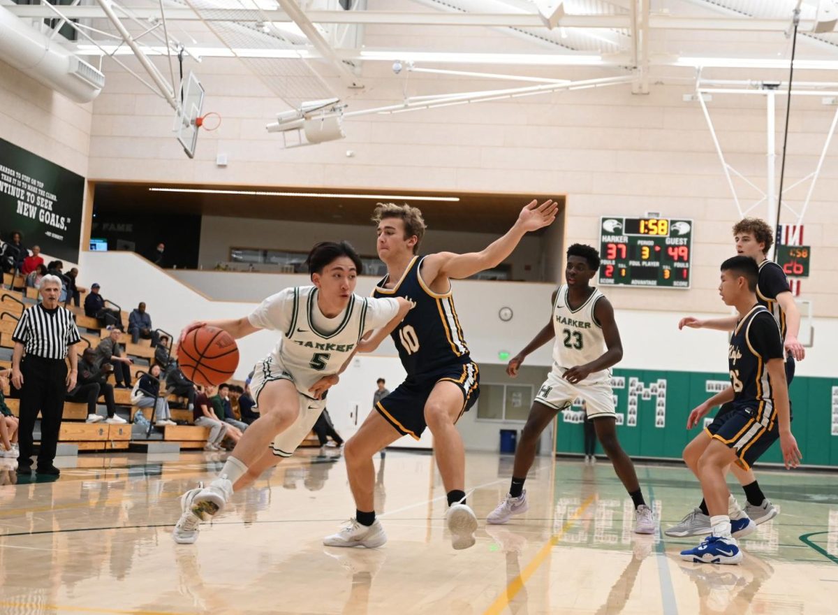 Point guard Gary Jin (12) powers past a defender on a drive toward the hoop. The Eagles held their lead through the first quarter.