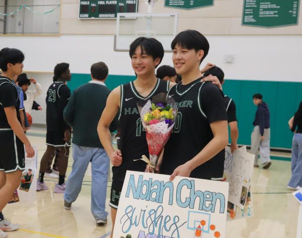 Varsity boys basketball players Lucas Huang (9) and Nolan Chen (12) take a photo together. “All my teammates around me, the energy that they had and the crowd had in the game was great,” Nolan said.