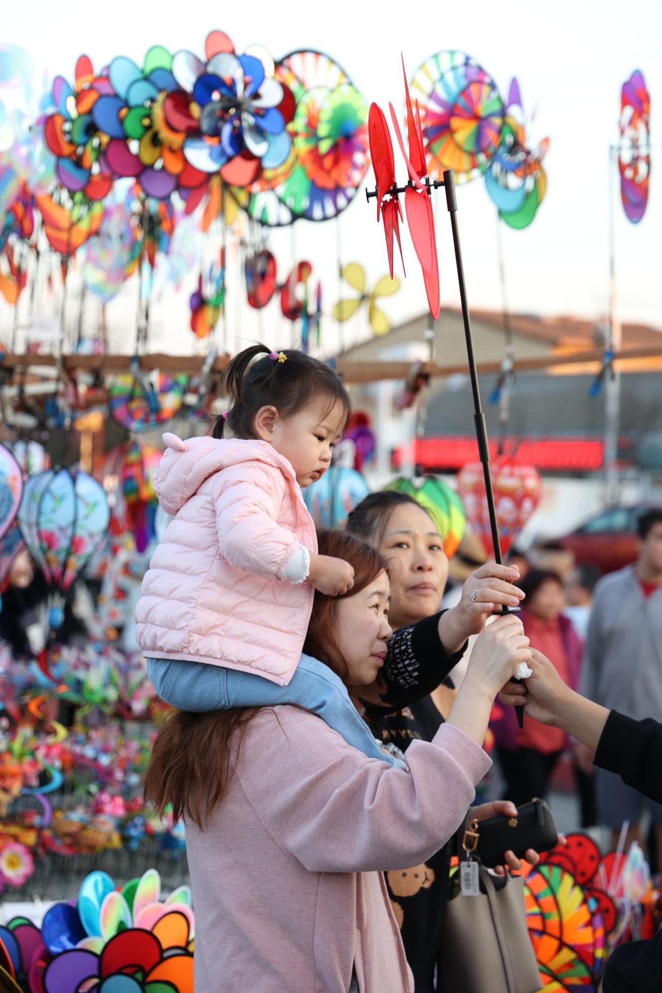 A family browses the selection of toys and trinkets sold by street vendors in Chinatown, San Francisco. The annual celebration in Chinatown features extensive merchant corridors as well as a parade.