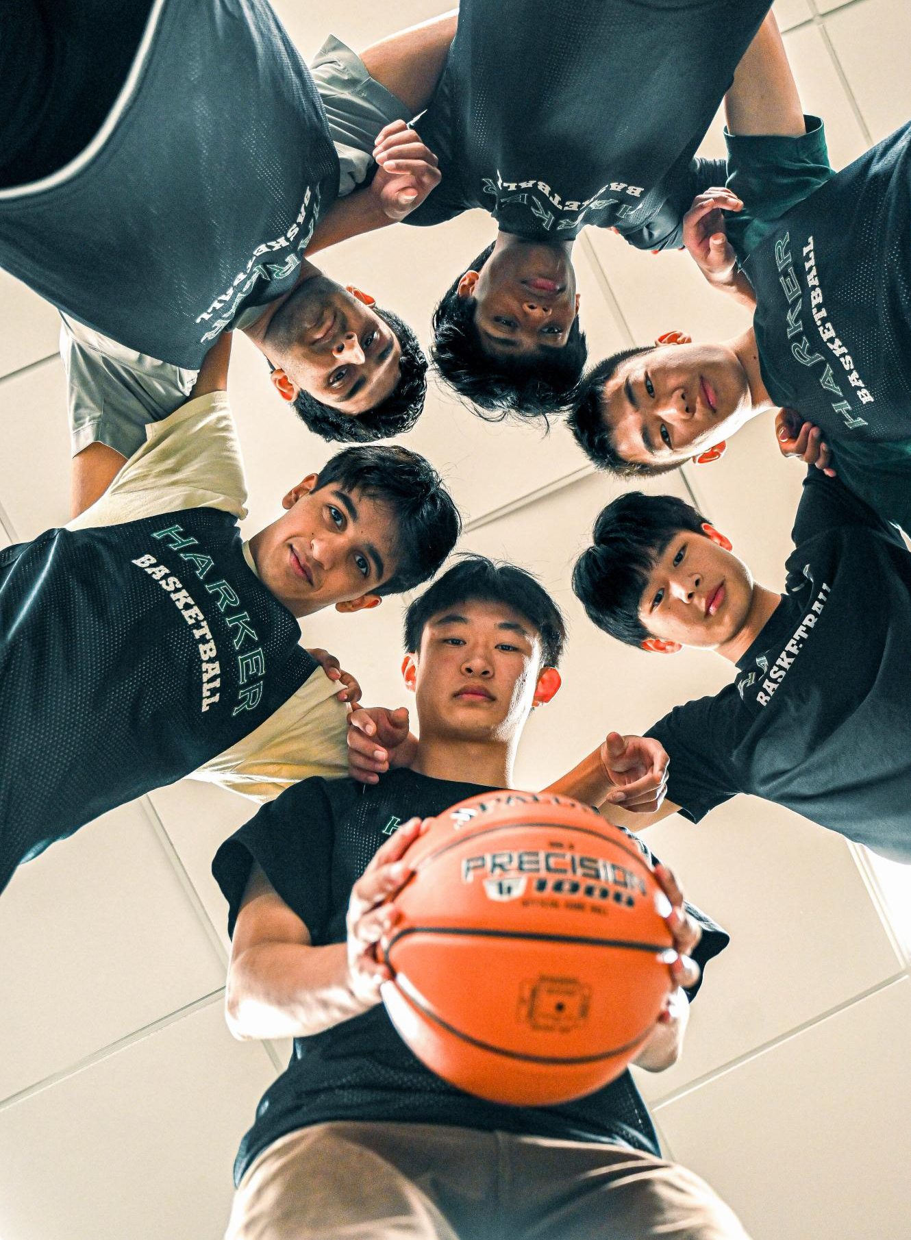 Varsity boys basketball captains Vyom Vidyarthi, Advay Monga and Bowen Xia (12) lead a team huddle. The captains frequently take on the responsibility of motivating the team to improve on-court morale and performance.