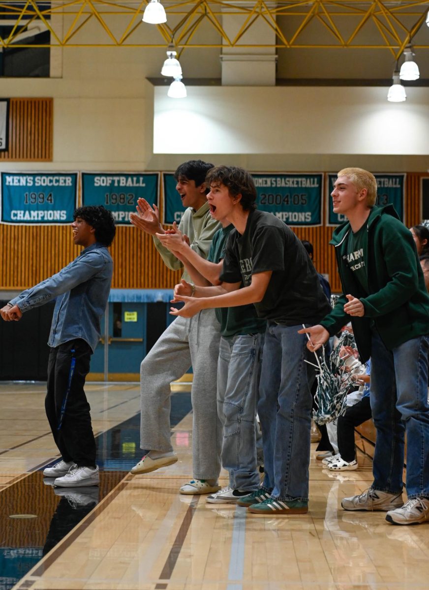 Seniors Rayan Arya, Advay Monga, Liam Jeffers and Kaleb Goldin jump to their feet to celebrate an Eagles basket. Throughout the match, the crowd stomped their feet and chanted encouragement at the team, filling the gym with energy.