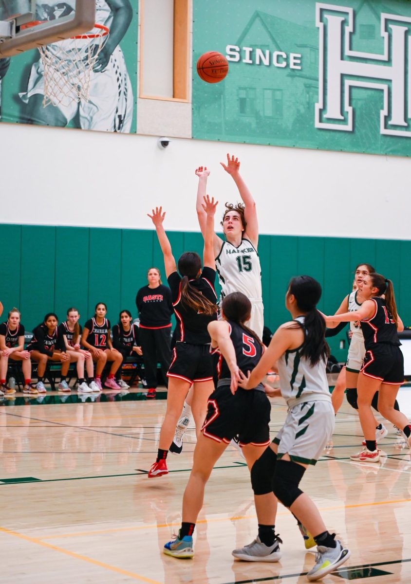 Center Emily Mitnick (12) floats a shot while guarded by a Castilleja defender. By frequently attacking the paint, the Eagles stormed back from a 5-point halftime deficit to win 53-35.