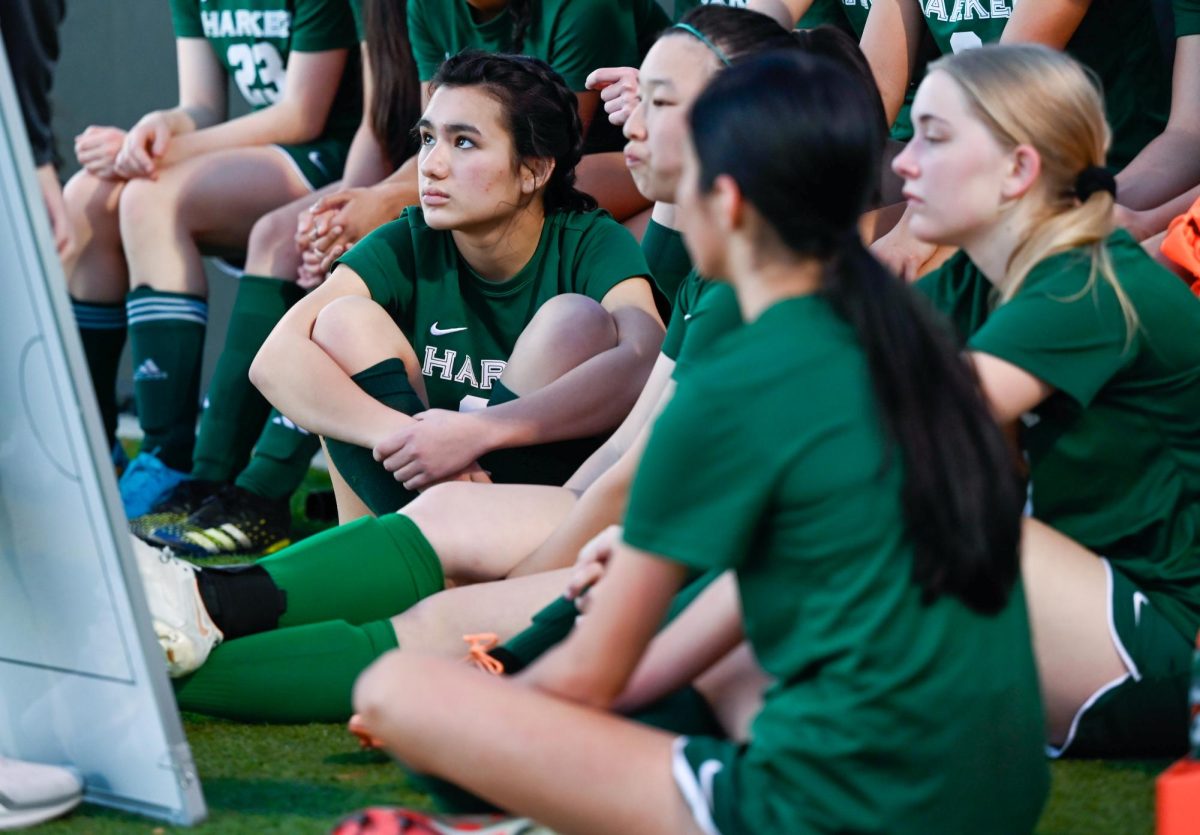 The varsity girls soccer team huddles around the white board during a timeout to discuss the game plan. This year was head coach Brandon Pena's first year, so the team placed a heavy emphasis on building team chemistry.