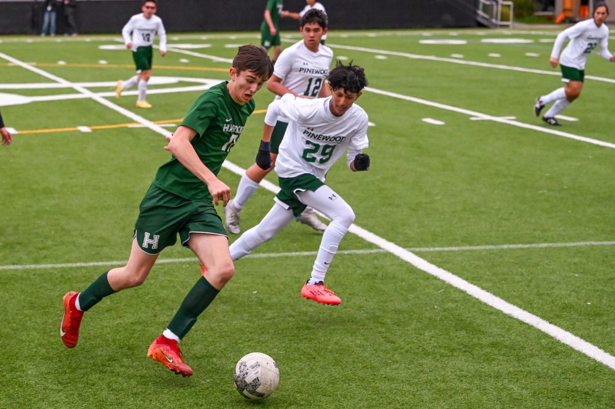 Forward Vova Shchegrov (10) dribbles the ball down the sideline past Pinewood defenders during their game on Feb. 12. Vova scored the final goal of the game, securing Harker’s win.