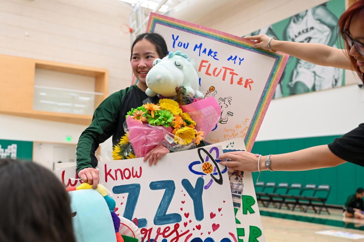 Guard Isabella Lo (12) receives posters, flowers and plushies during varsity girls basketball senior night. After the game against Eastside concluded, the seniors took photos with their friends to celebrate their last home game of their high school careers.