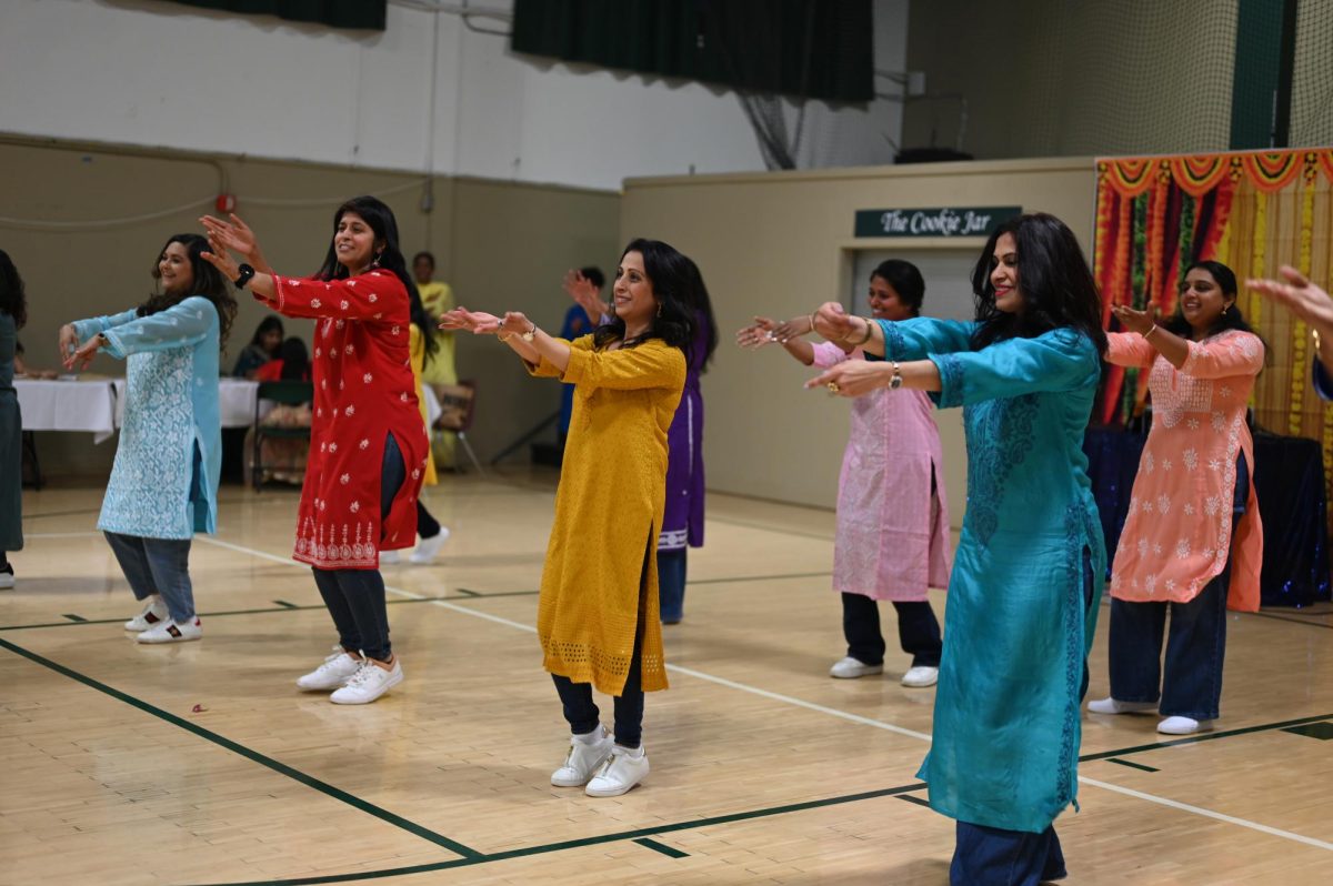 Parents of seniors smile as they dance to “Gallan Godiyan” and “Lungi Dance.” They rehearsed for three hours every Friday during the two weeks leading up to Bollywood night.