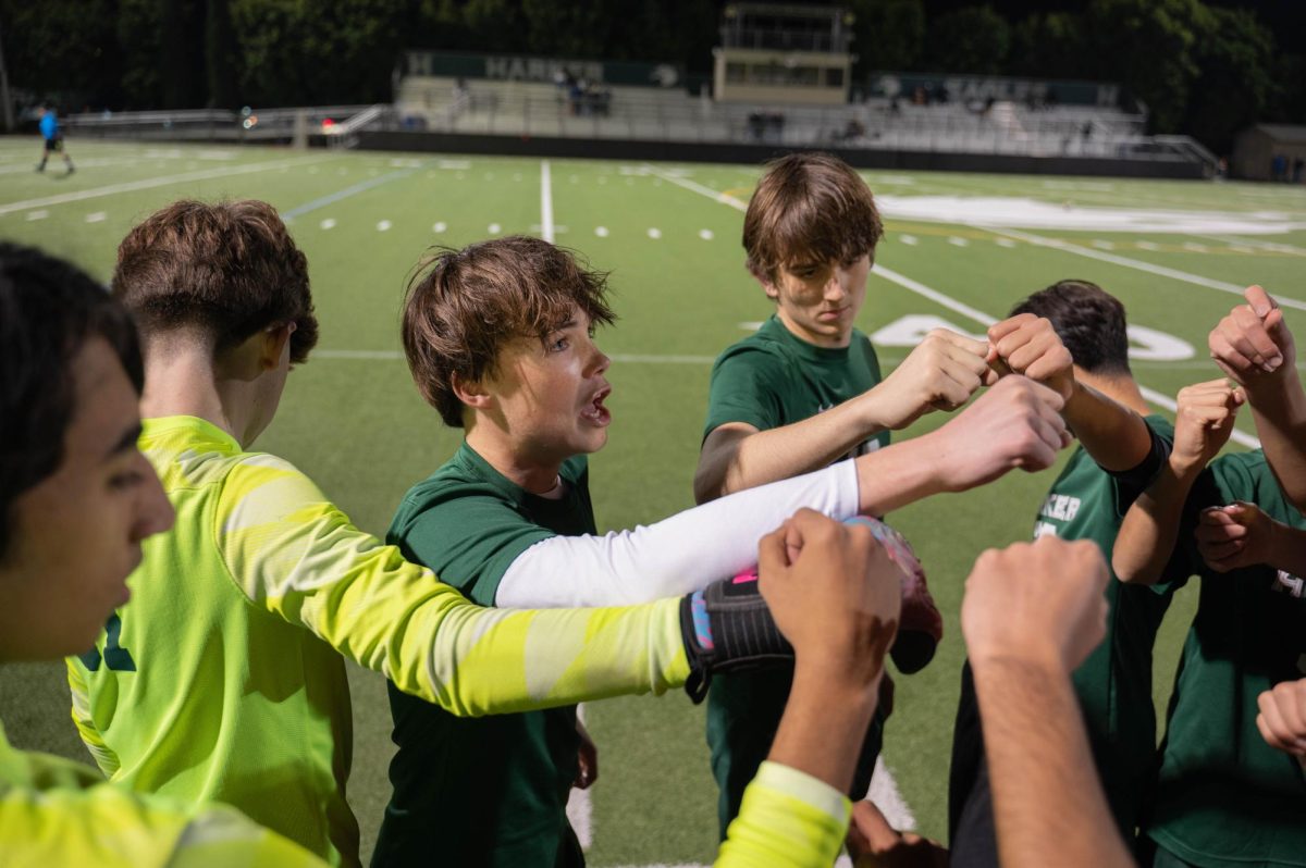 Varsity boys soccer player Ryder Hewitt (11) leads a team cheer before a match on Davis Field. Playing on their home turf provides the team an advantage as they are more accustomed to the environment. 