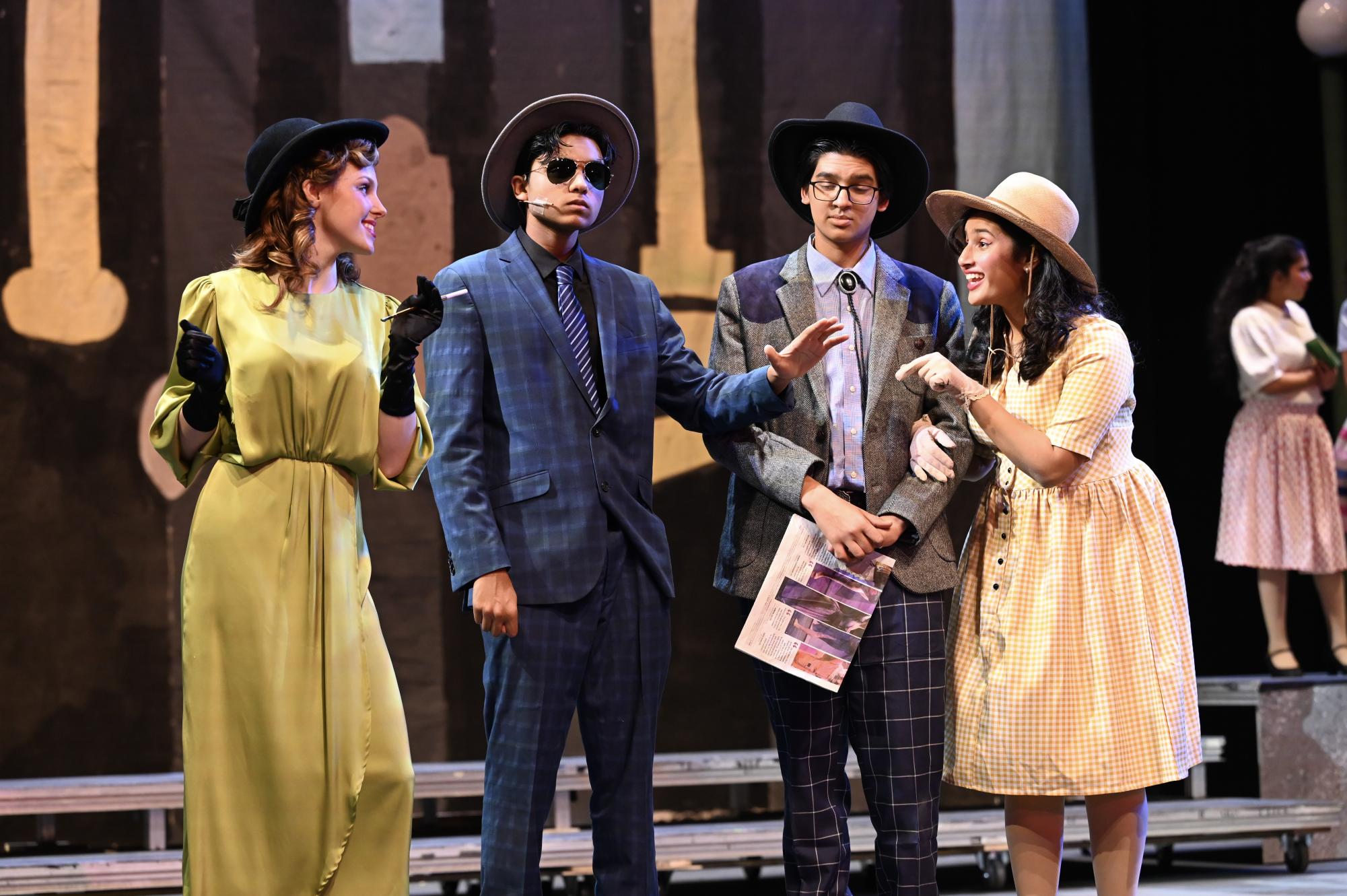 During dress rehearsal, actors playing New York socialites speak with each other in the opening sequence of the musical. The opening of Guys and Dolls showcases the many facets of New York life.