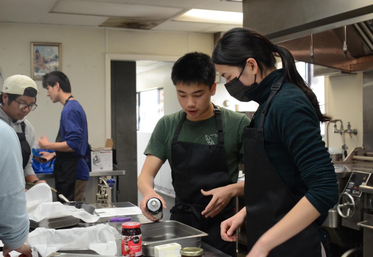 Celina Xu (11) and Victor Gong (12) prepare the baking sheet for the brownies. “I enjoy cooking because you get to see something from start to finish, and it’s a very calming process—the act of chopping or mixing things," Celina said.