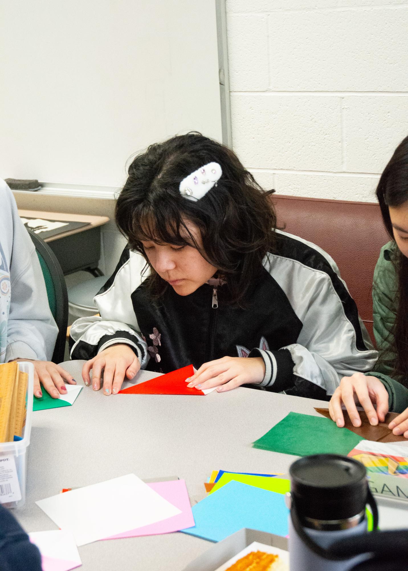 Ashley Dickerson (9) folds a piece of paper to make origami. The Mythology Club, Origami Club and Japanese National Honor Society held a collaborative event on Monday.