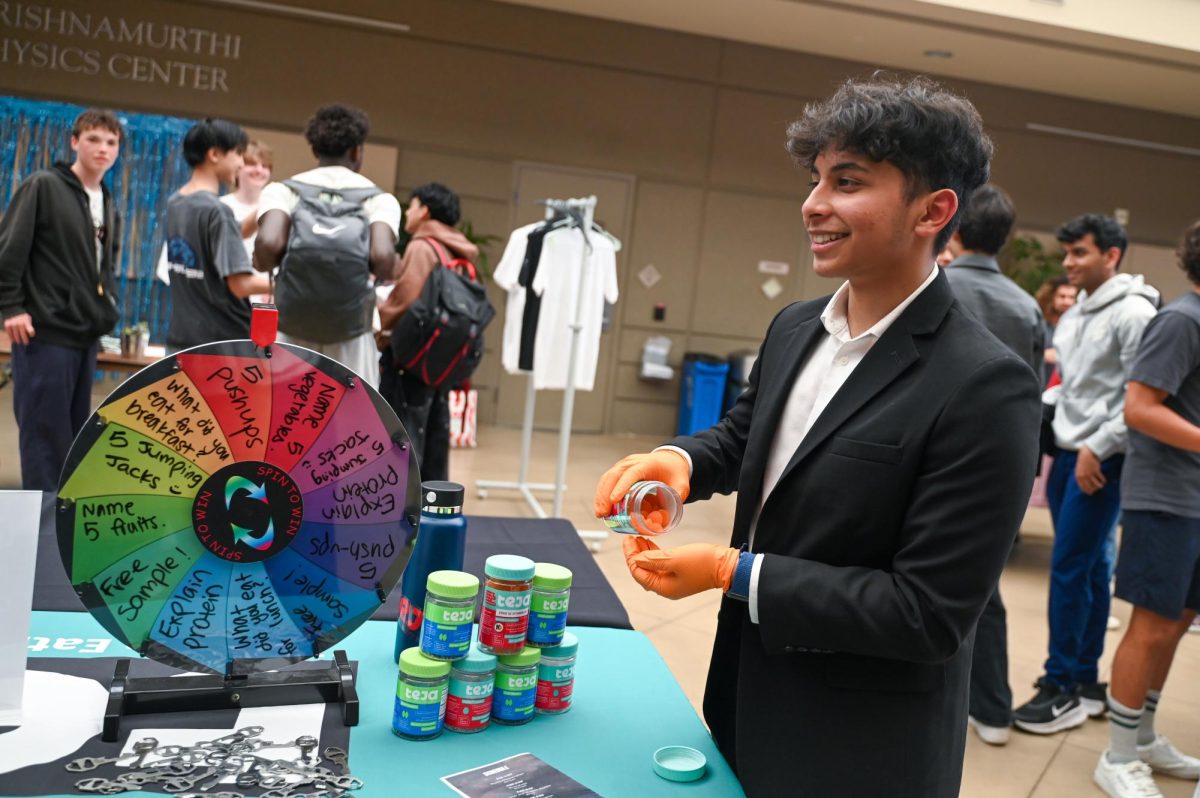 Founder of Teja Gummies Sriteja Kataru (12) hands out samples at his booth. Students engaged by spinning a challenge wheel featuring trivia and physical tasks to win prizes.
