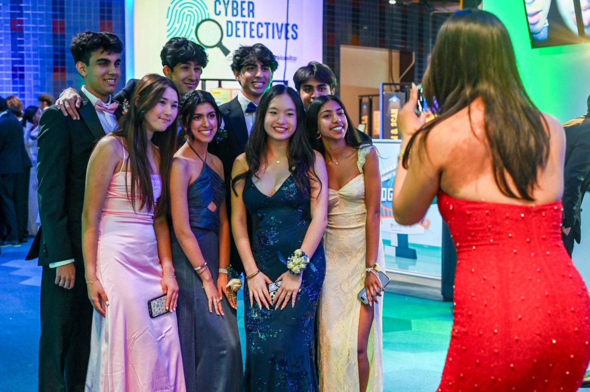 A group of juniors pose before the camera near the Tech Interactive exhibits. Students commemorated their school year with a night of dancing and celebration at prom on April 19.