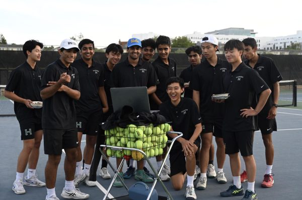 The varsity boys tennis team laugh as the watch a video honoring the seniors. Each non-senior recorded a 30-second segment expressing their grattitude.