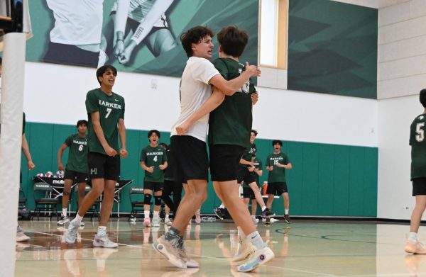Senior libero Jacob Smith gives outside hitter Topaz Lee (11) a hug to celebrate a point. Topaz made multiple kills throughout the game, scoring many points for the team.