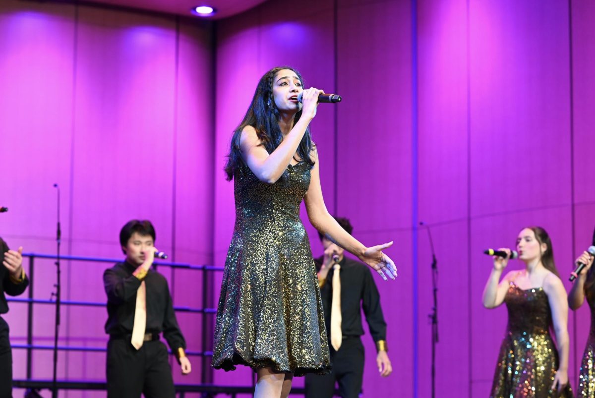 Senior Shruti Srinivasan sings a solo during Downbeat's performance. All of the upper school choral groups came together in the last concert of the year, "How Can I keep From Singing."