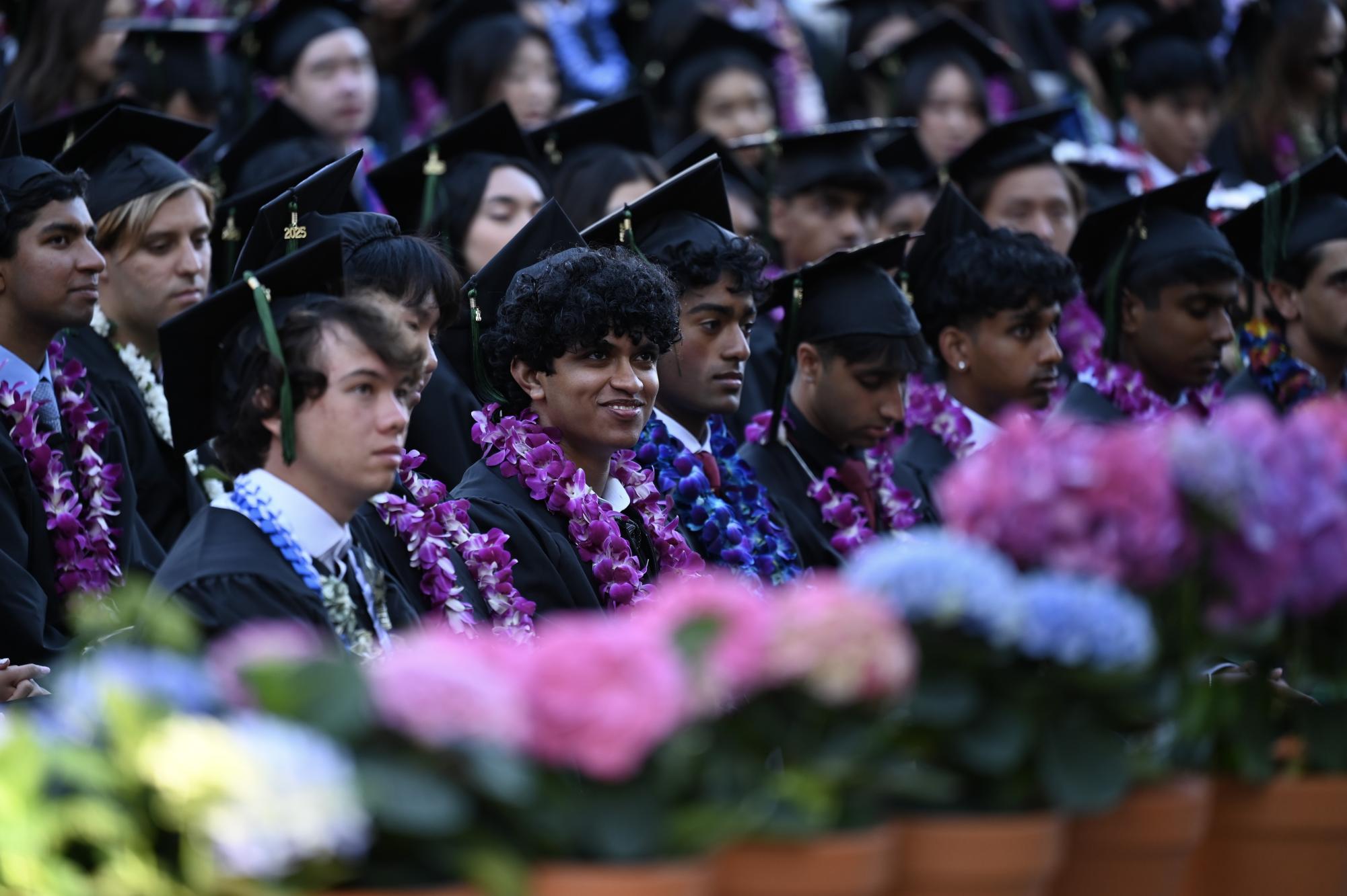 Shiven Balaji ('25) chuckles as he listens to keynote speaker Anita Modi ('04). She advised the graduating class to continue to persist despite challenges and take risks.