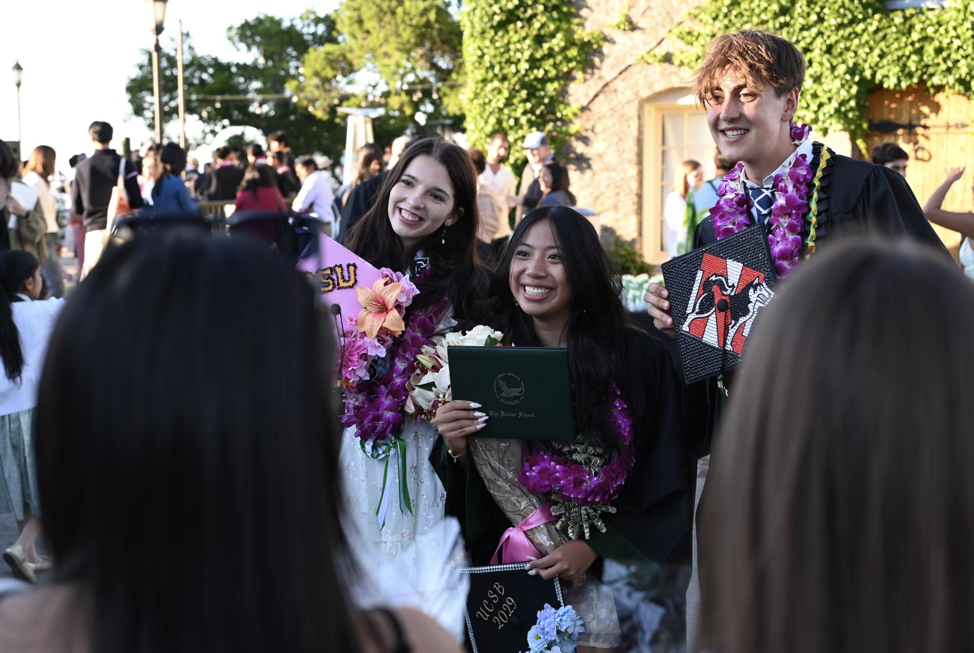 Hannah Streeper ('25), Caitlyn Wong ('25) and Haden Andrews ('25) take pictures with their graduation caps. Graduation marked the end of four years at Harker for the class of 2025, from being the first on campus at the end of the pandemic in ninth grade to creating bittersweet memories as seniors.