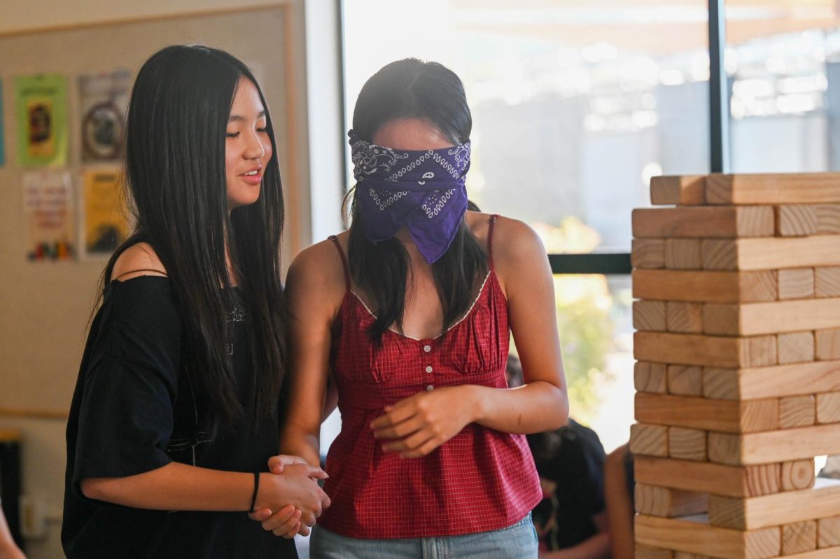 Seniors Emma Li and Joy Hu participate in a game of blindfolded Jenga with their friends. The workshop was made to forge deeper bonds within the senior class.