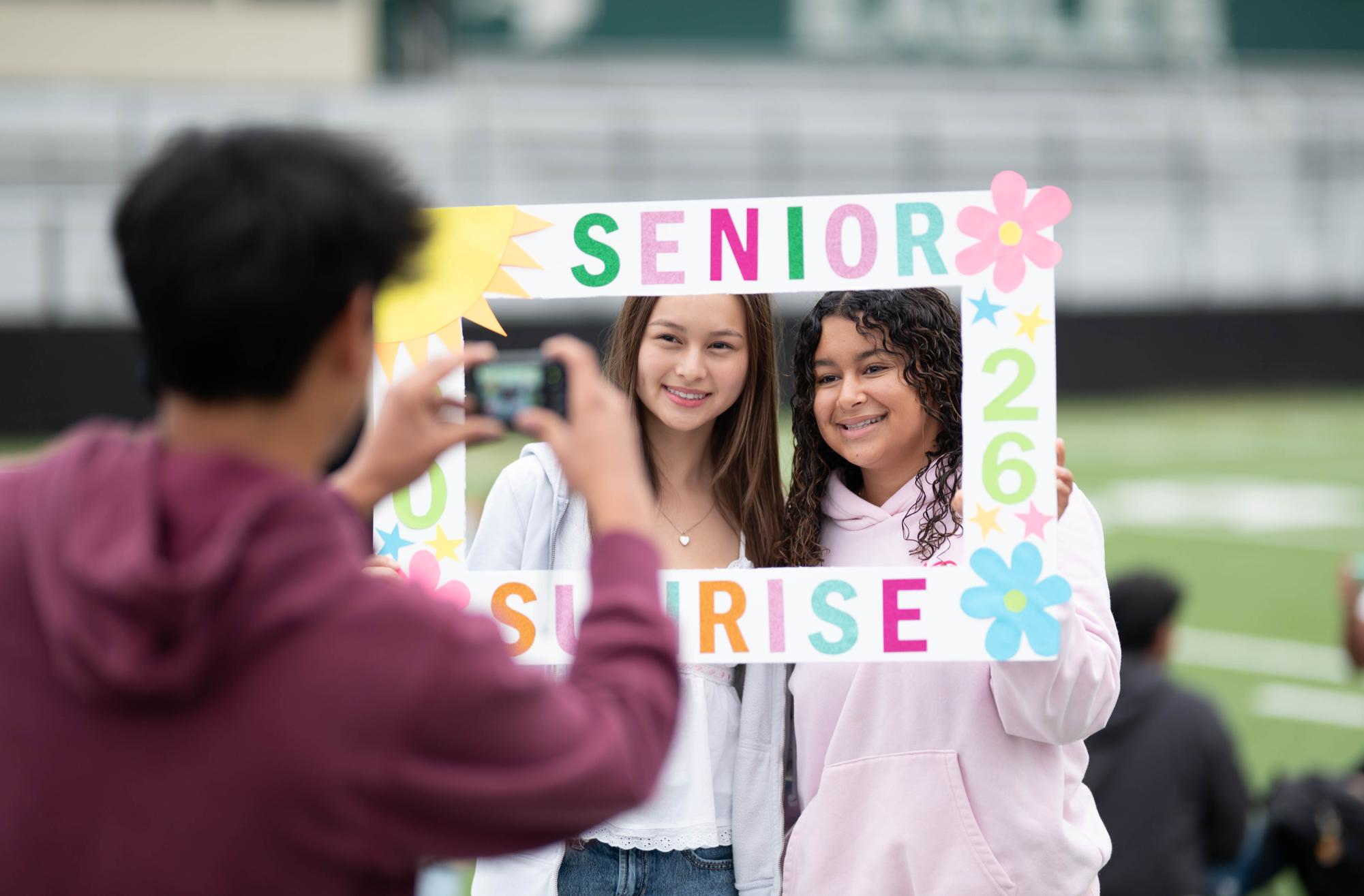 Seniors Sophia Bagley and Judi Abdelrazik pose for a photo with a handmade sign. The Class of 2026 arrived on campus at 6 a.m. to kick off the school year as per tradition.
