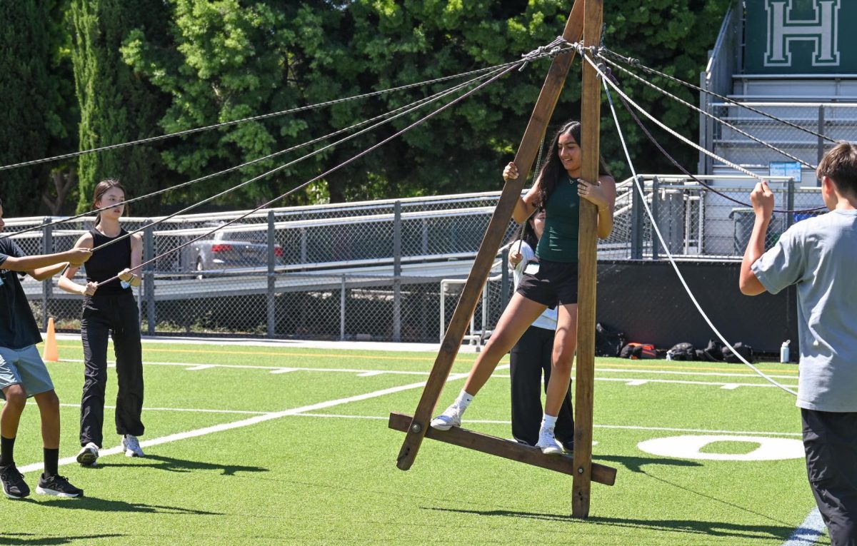 Rhea Sharma (9) steadies herself on the A-frame as her advisory teammates grip the guide ropes. Her group raced against two other advisories and crossed the finish line first.