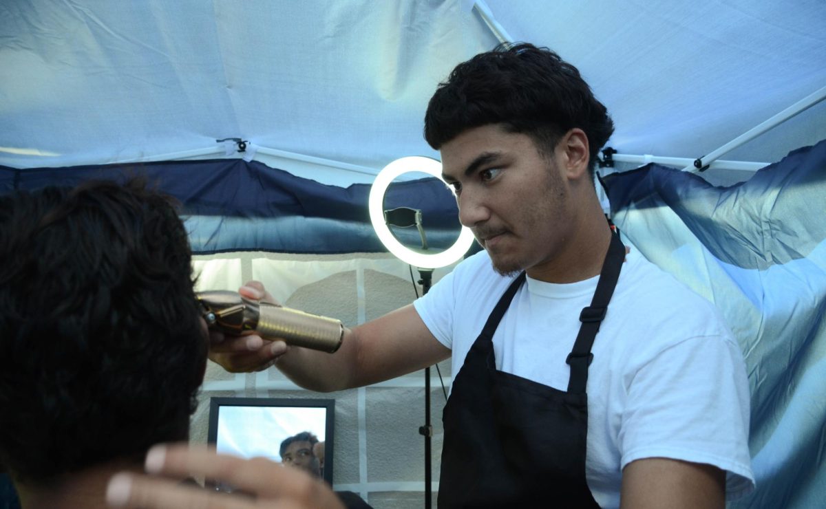 Barber Zane Sharif trims a clients hair. “You imagine your client as a canvas, and you’re almost painting,” Sharif said. “Your tools and razors are your brushes. So, in a sense, it is almost the same thing as art."