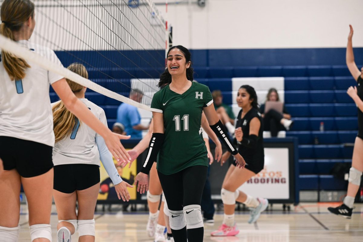 Libero Zoya Khera (10) runs by the net, leading the Harker JV team in high-fiving the Branham team after their victory. The Eagles won the game in two sets, with a close 25-23 in the first set and 25-13 in the second set.