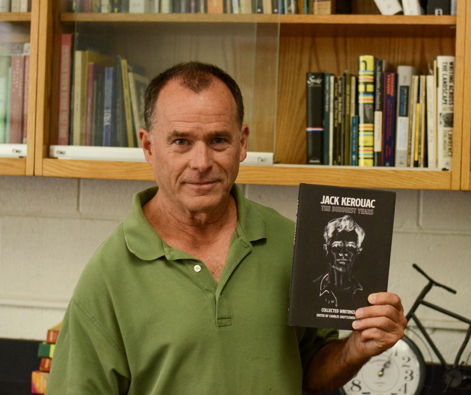 Upper school English teacher Charles Shuttleworth poses with his recently published book titled "The Buddhist Years," a collection of American poet Jack Kerouac's writings. His book was featured in a BBC radio interview and an article in The Guardian this past year.
