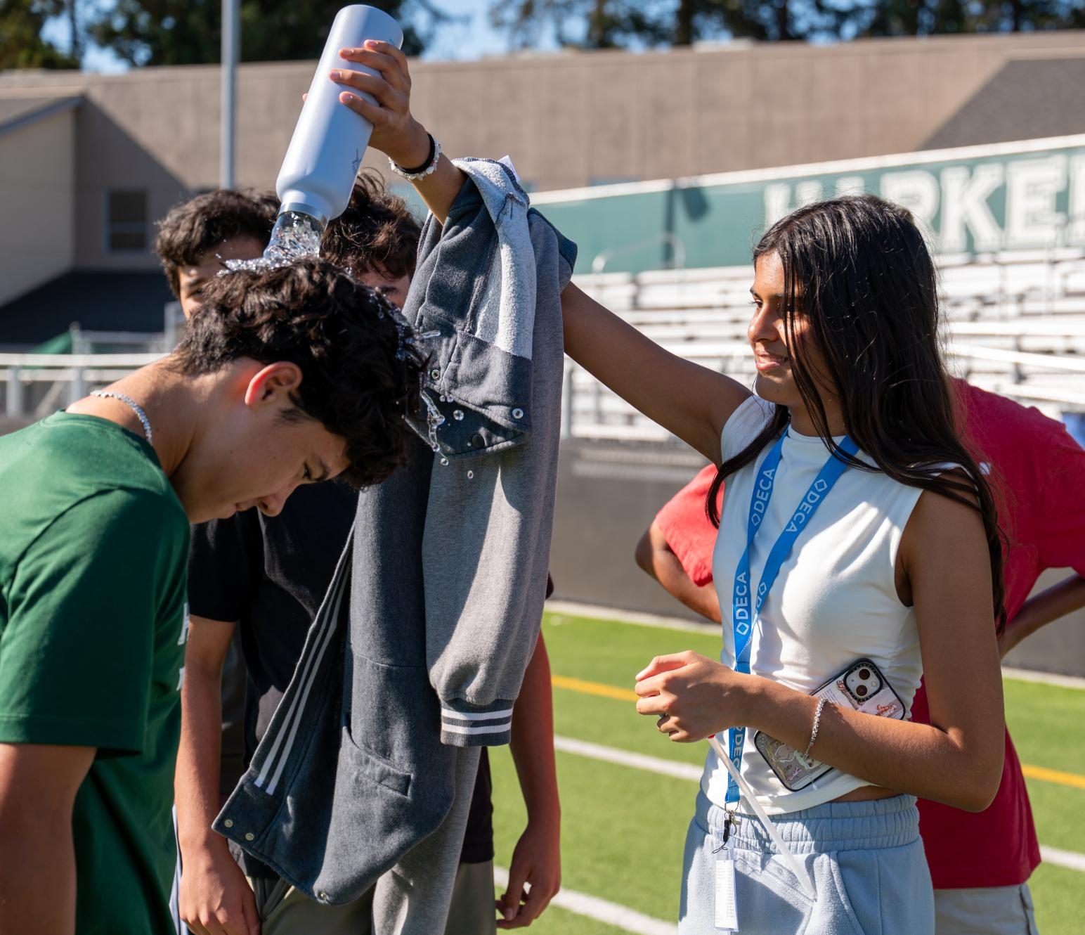 Resham Lamba (9) pours water on Director of Finance David Kelly (11) during the scavenger hunt. Stations across campus featured activities like pictionary with Vice President of Operations Nathaniel Idicula (11) and a race with Director of Membership Kai Nishimura (11).