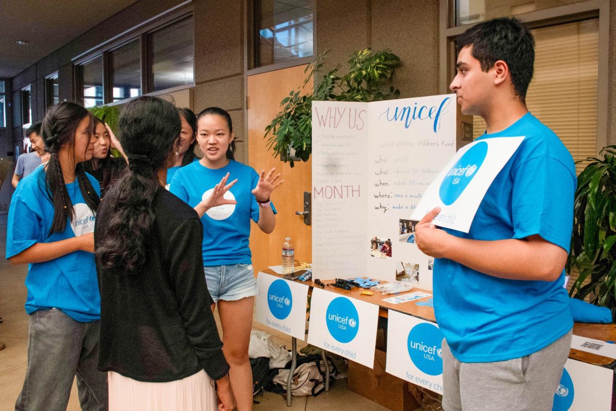 Phoebe Lee (11) and Omar Khan (11) introduces UNICEF's initiatives to Dr. Aiyer. UNICEF advocates for children's rights around the world.