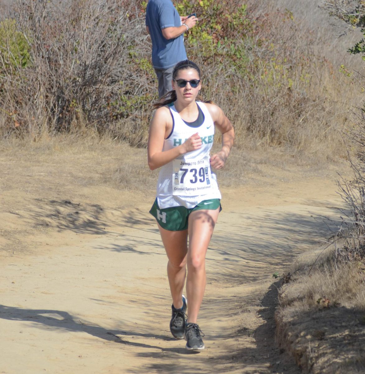 Emily Bryan (12) races across the last stretch of the course. The course featured numerous rolling hills and downward slopes.